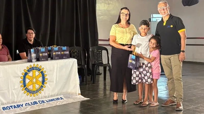 Mãe e duas crianças recebendo óculos no evento